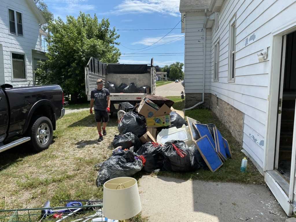 Crew members loading household items beside a house