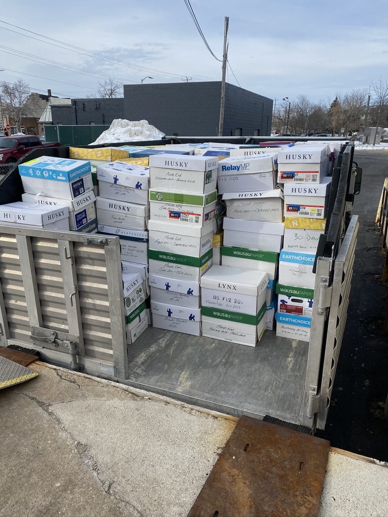 Open trailer loaded with stacked boxes and metal items